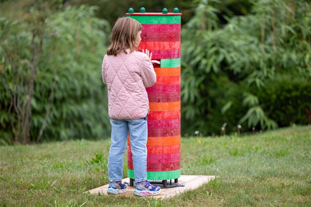 Bambina al gioco a torre colorata nel prato